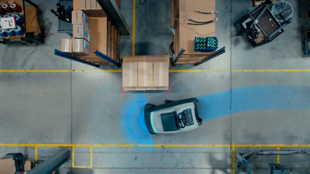 Nilfisk SC50 autonomous scrubber navigating in a warehouse