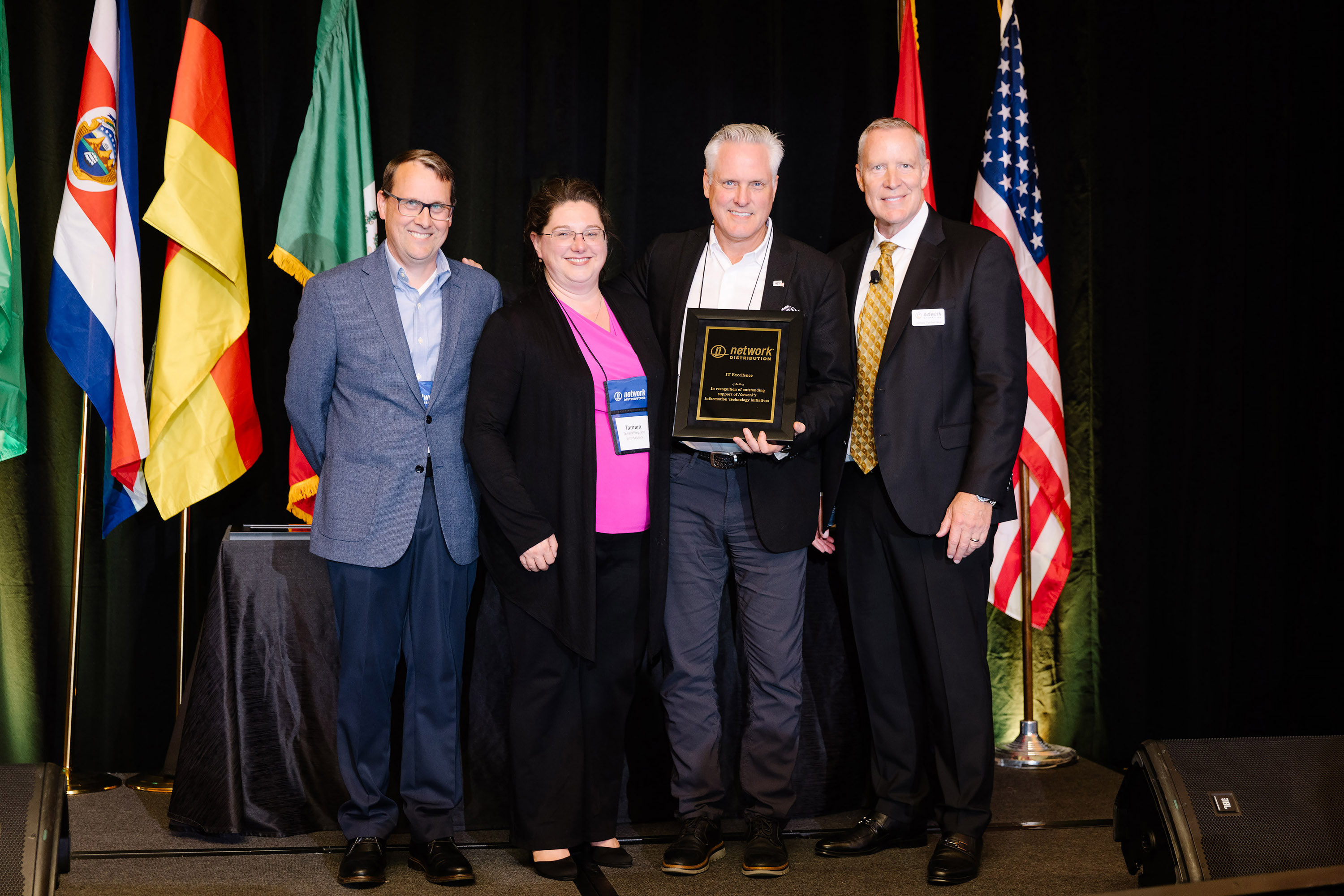 Ed Allen, Tamara Ferguson, and Jeff Larson receiving Network Distribution Member Award from James Timberlake