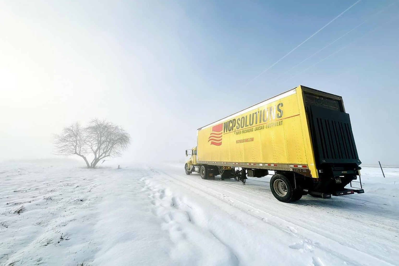 WCP Solutions yellow truck on a snow and ice covered road