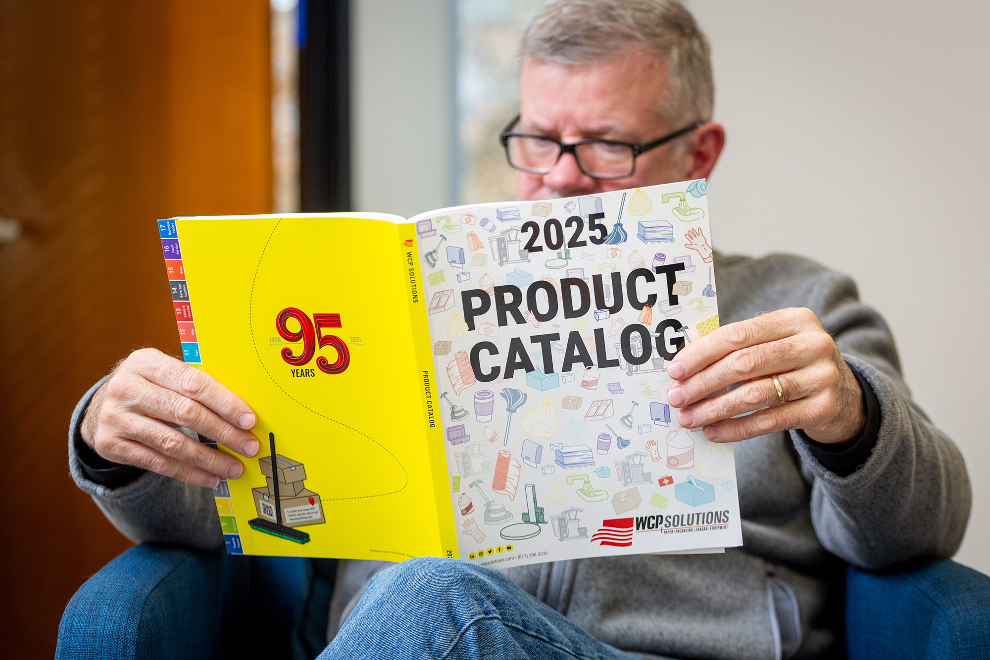 Person reading the 2025 WCP Solutions Industrial Product Catalog